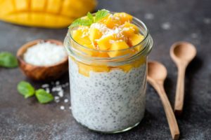 A close-up of chia pudding with peaches and coconut.